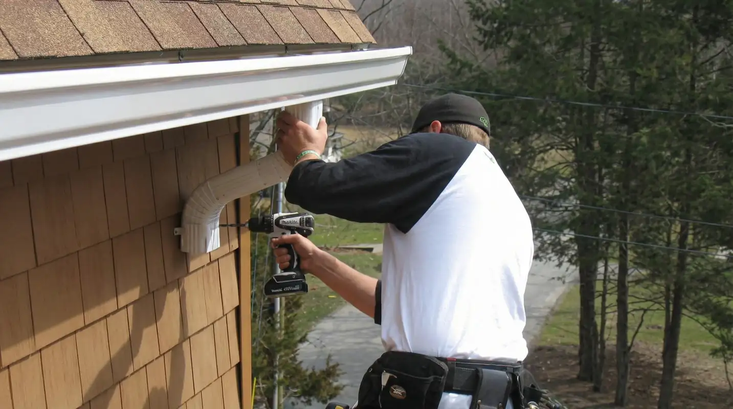 Professional contractor installing tan vinyl siding panels on a residential home exterior in Austin, TX